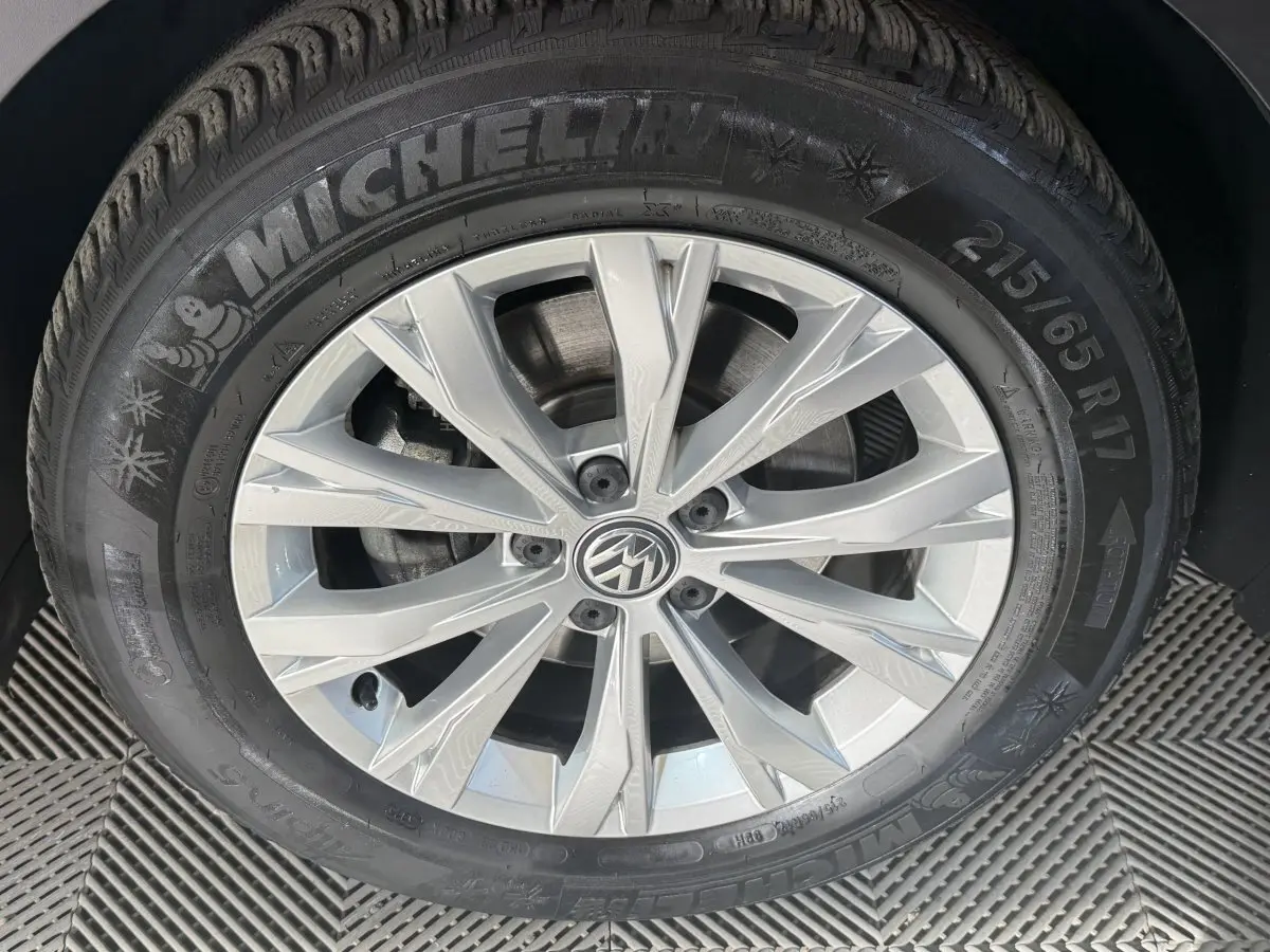 Gros plan sur la jante alliage argentée et pneu Michelin d’un Volkswagen Tiguan gris clair, vue latérale.