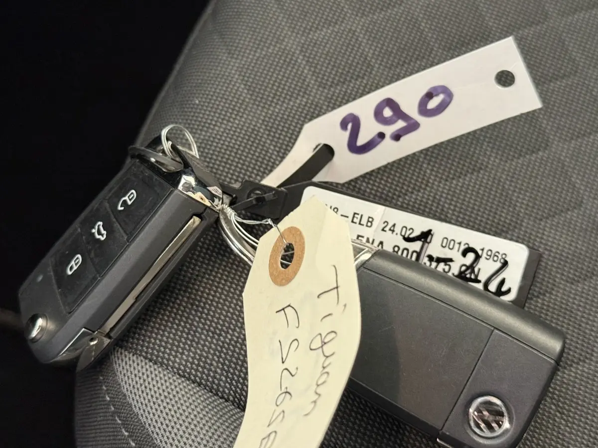 Gros plan sur la clé de contact noire du Volkswagen Tiguan 2.0 TDI gris clair posée sur un siège tissu.