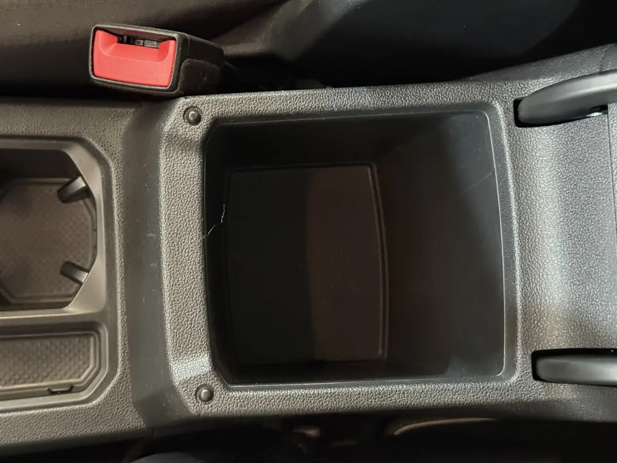 Gros plan sur le rangement central noir entre les sièges avant du Volkswagen Tiguan 2.0 TDI 150 DSG7 Confortline Business.