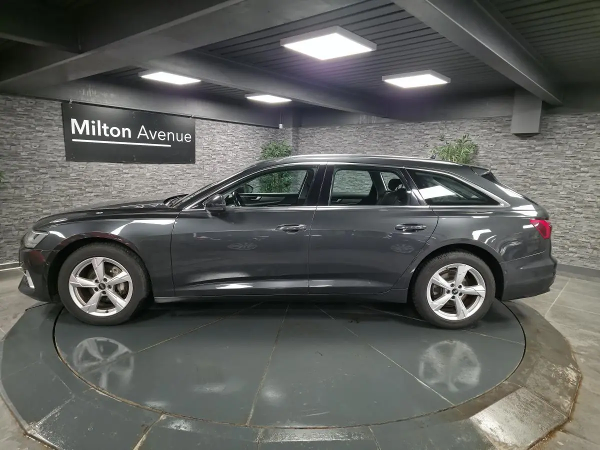 Profil côté gauche d'une Audi A6 Avant gris métallisé 2022 avec jantes 5 branches et toit ouvrant visible.