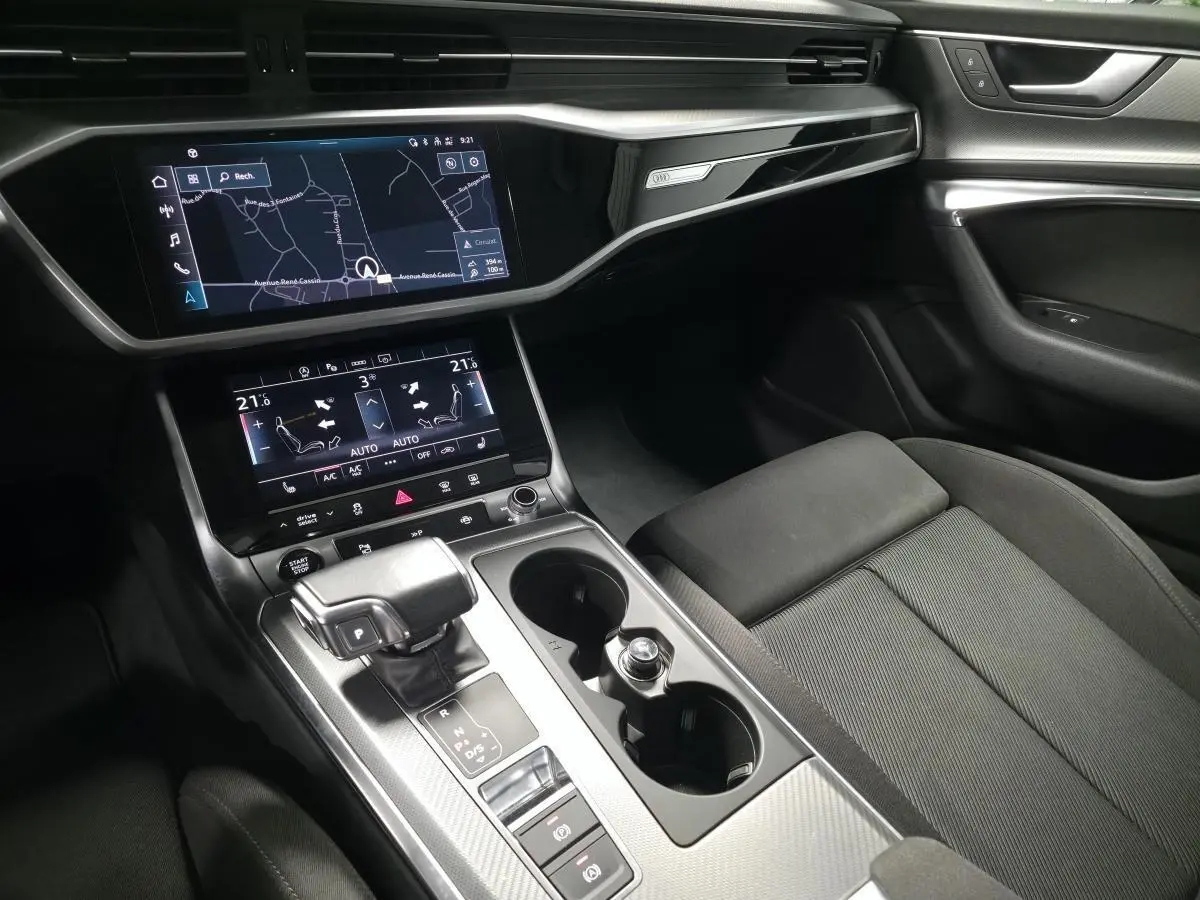Intérieur noir de l'Audi A6 Avant 2022, vue sur console centrale avec écran tactile et levier de vitesse automatique.