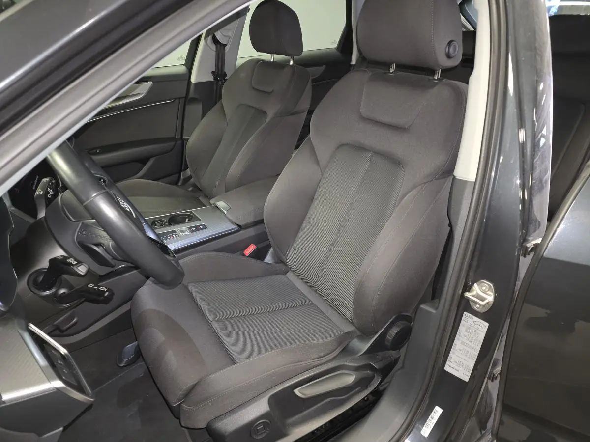 Vue intérieure côté conducteur de l'Audi A6 Avant gris 2022, sièges sport en microfibre noire et console centrale alu brossé.