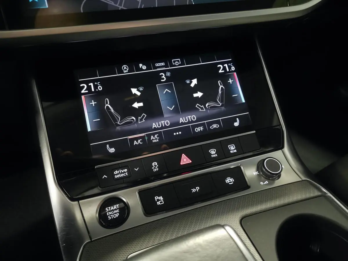 Gros plan sur la console centrale de l'Audi A6 gris, écran tactile affichant la climatisation bi-zone à 21°C.