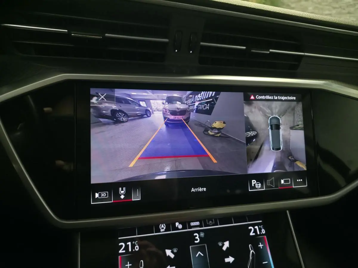 Écran de caméra de recul et vue 360° dans un Audi A6 gris, affichage du système d'assistance au stationnement.