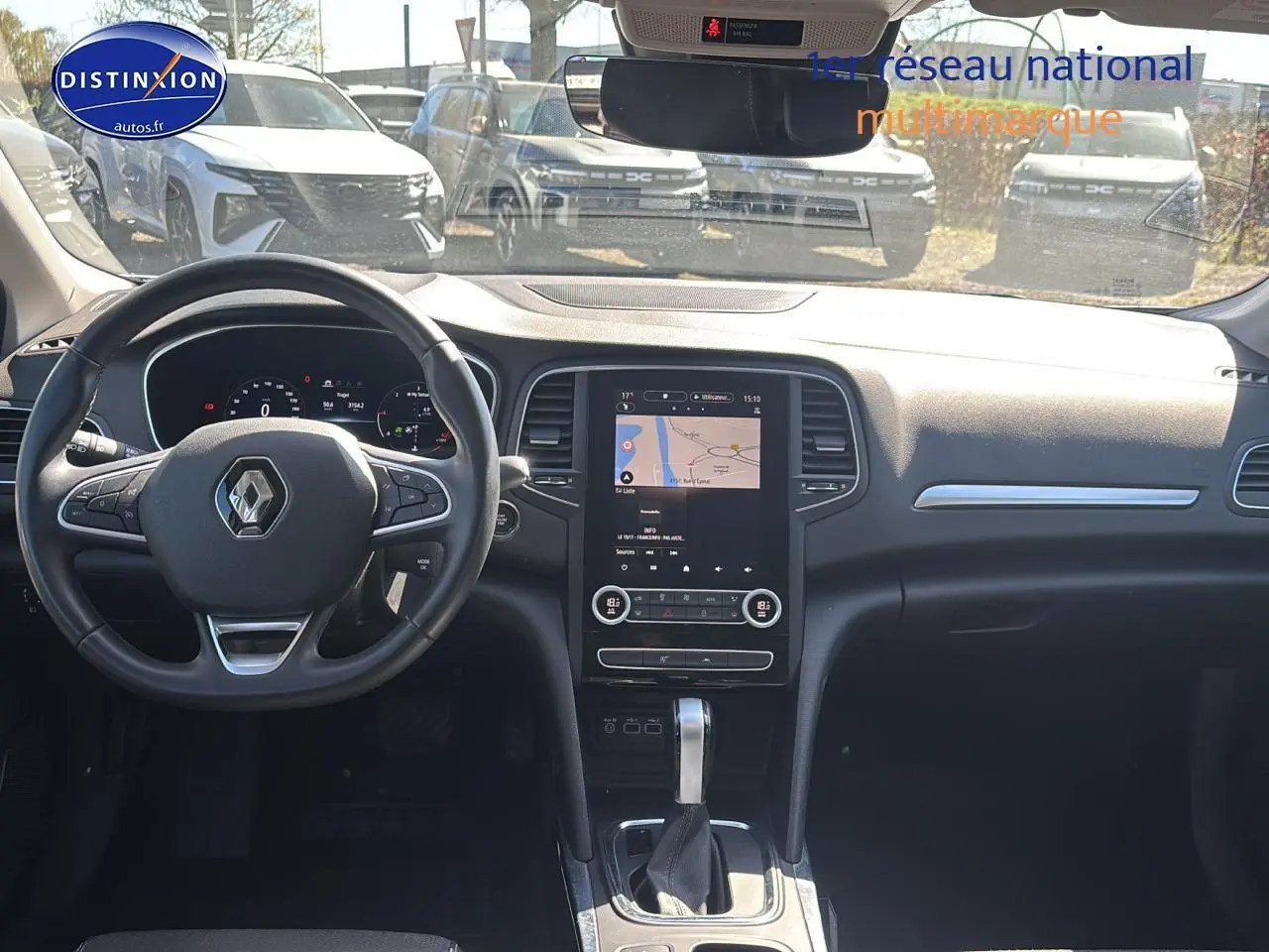 Vue intérieure avant du tableau de bord et volant de la Renault Mégane IV 1.5 Blue dCi gris Highland avec écran tactile central.