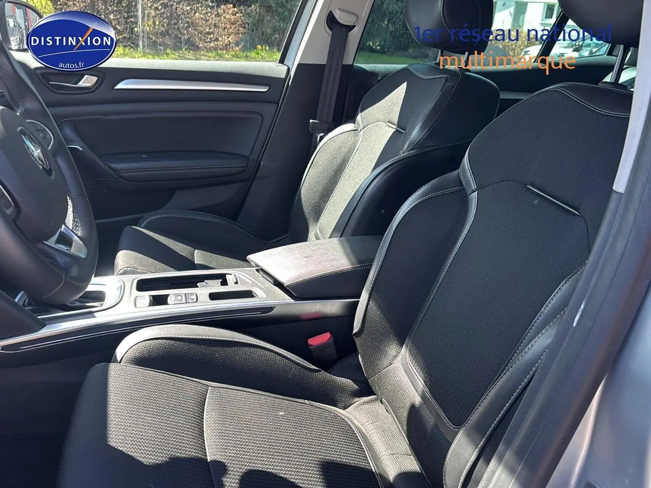 Vue intérieure côté conducteur de la Renault Mégane IV 1.5 Blue dCi 115 Techno EDC avec sièges noirs et console centrale.