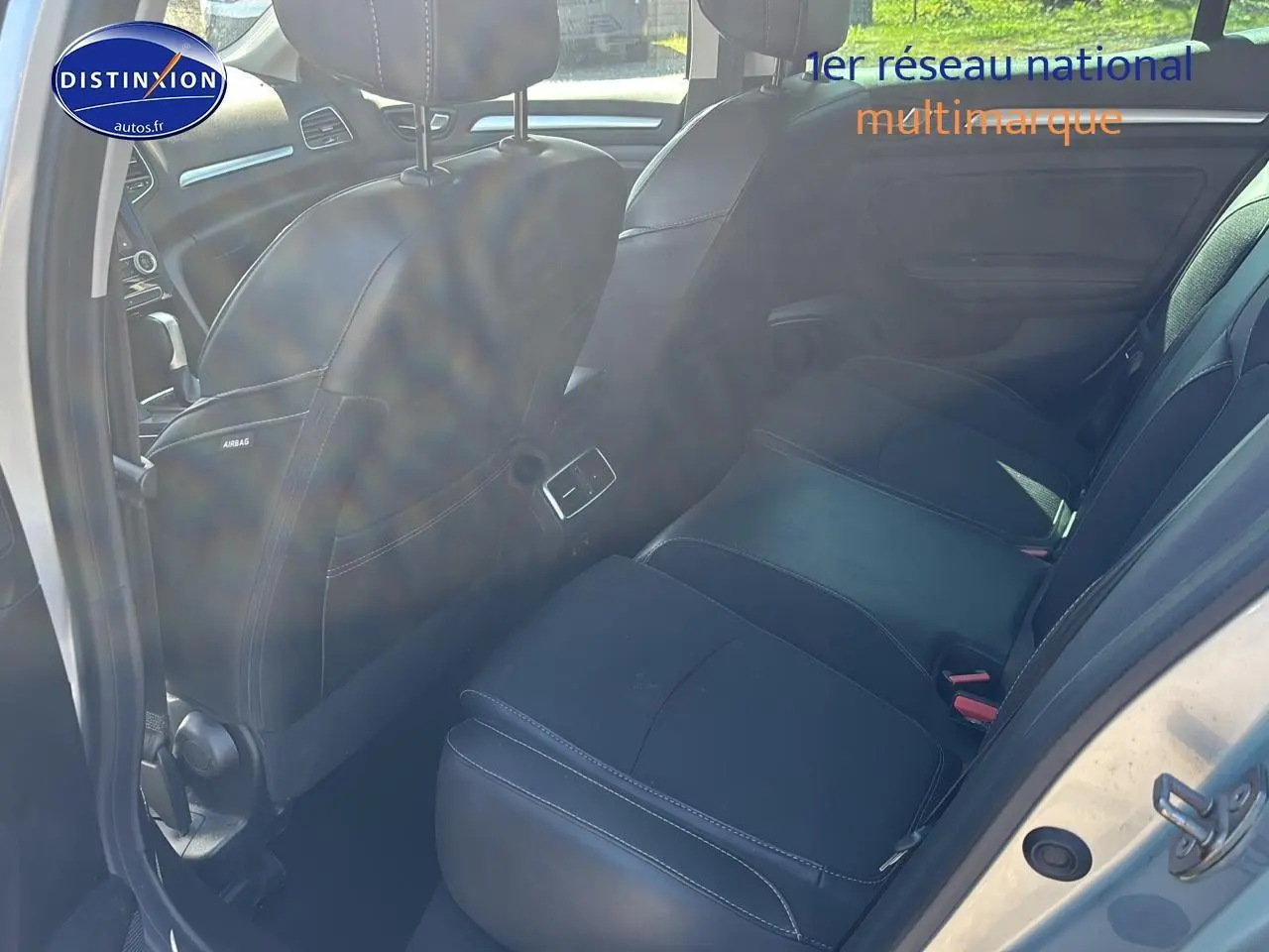Vue intérieure arrière côté gauche montrant les sièges noirs et la portière ouverte d'une Renault Mégane IV gris Highland.