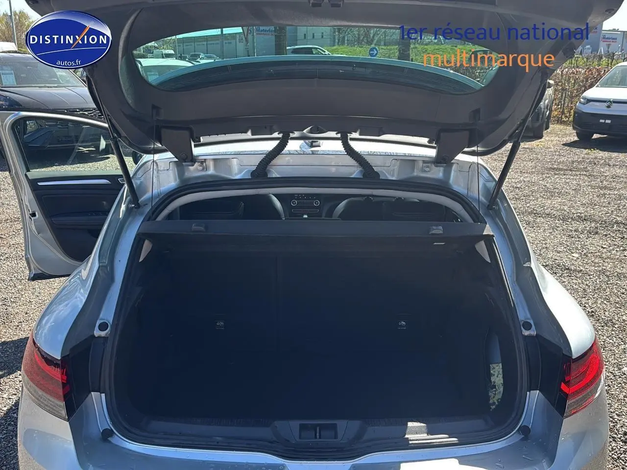 Vue arrière ouverte sur le coffre d’une Renault Mégane IV gris Highland 2023, porte arrière gauche ouverte.