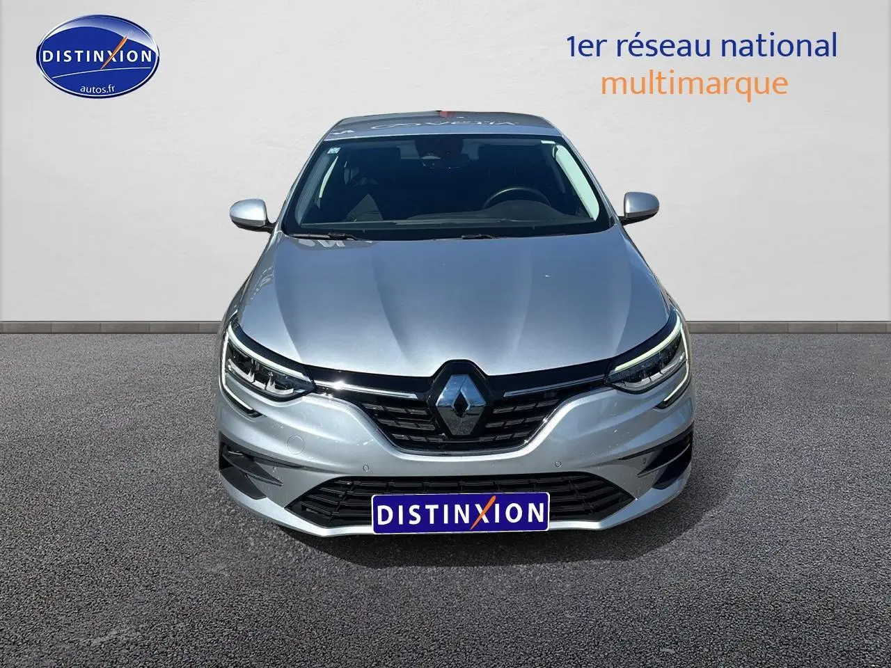 Vue de face d'une Renault Mégane IV gris Highland avec phares full LED et calandre noire brillante.