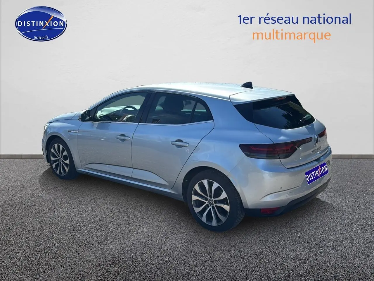 Vue 3/4 arrière droite d'une Renault Mégane IV gris Highland avec jantes alliage et vitres teintées.