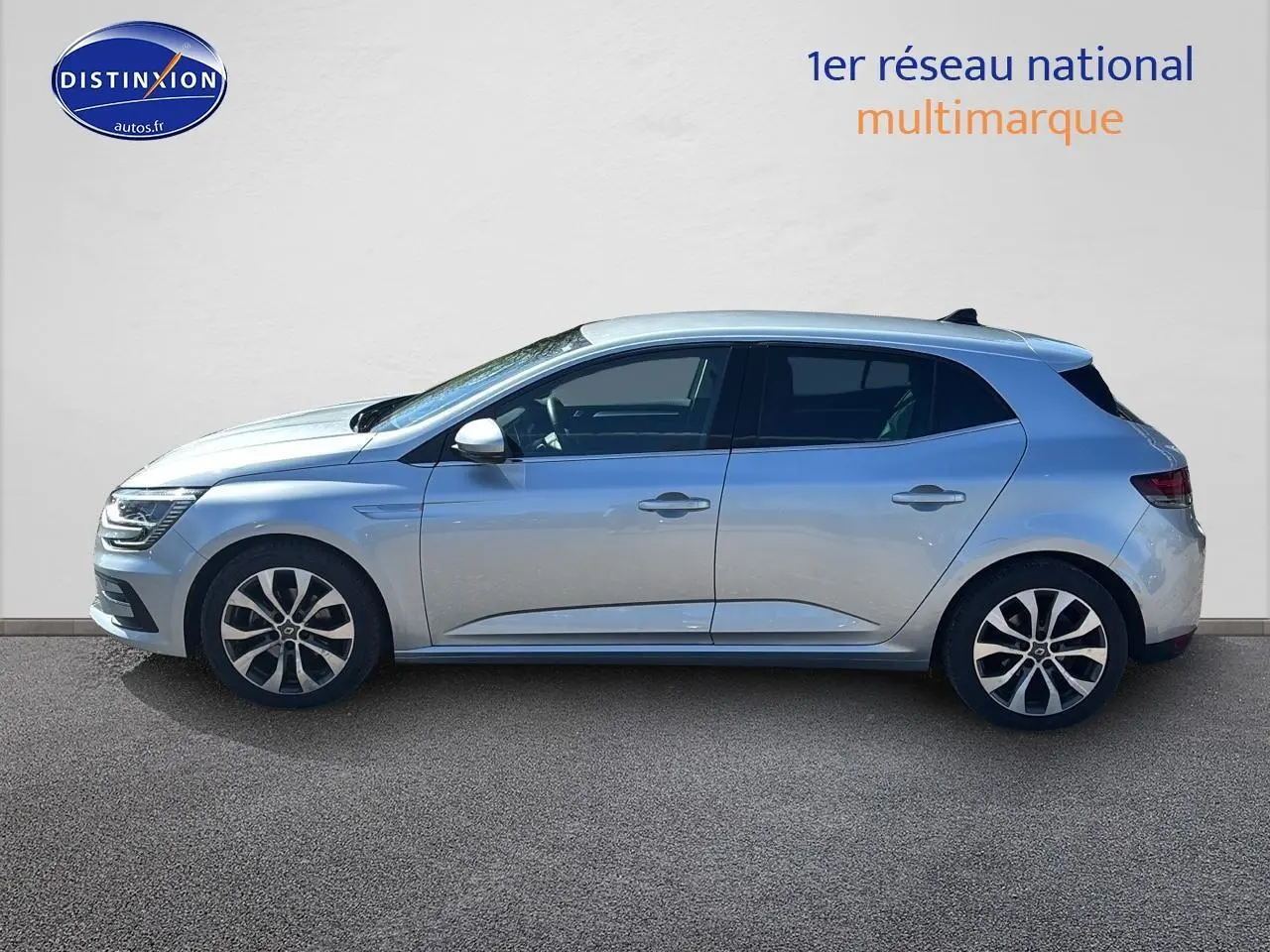 Profil latéral gauche d'une Renault Mégane IV gris Highland avec jantes alliage 17 pouces sur fond neutre.