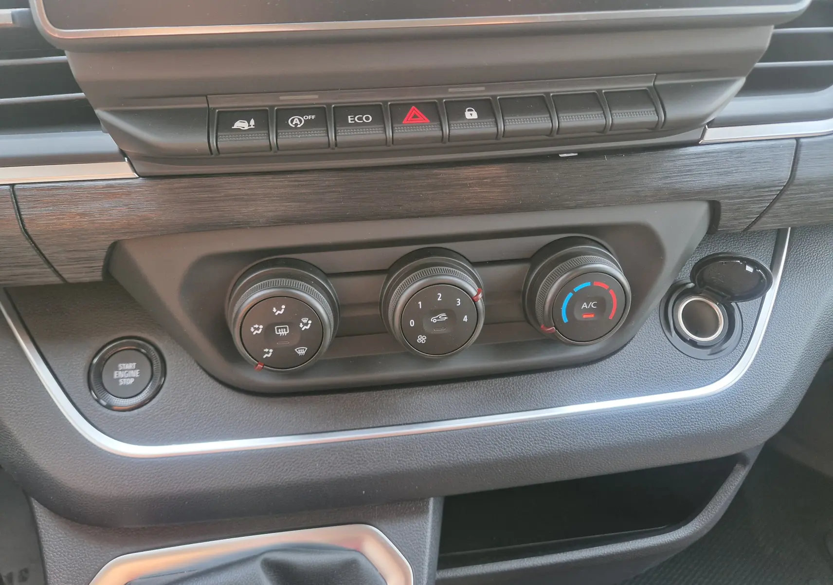 Gros plan sur la console centrale du Renault Trafic Combi 2026, montrant les commandes de climatisation et le bouton start/stop.