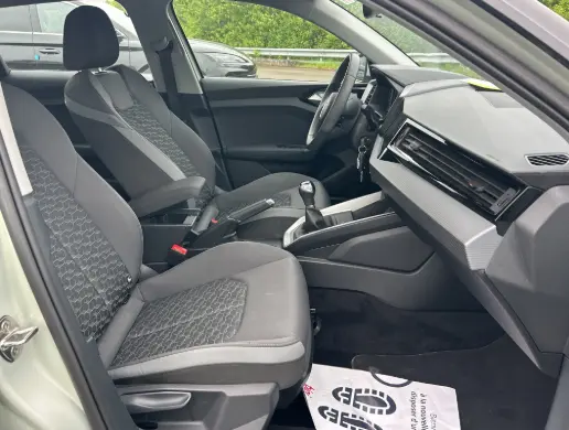 Vue intérieure côté conducteur de l'Audi A1 Sportback gris 2025, sièges sport et volant cuir avec cockpit numérique.