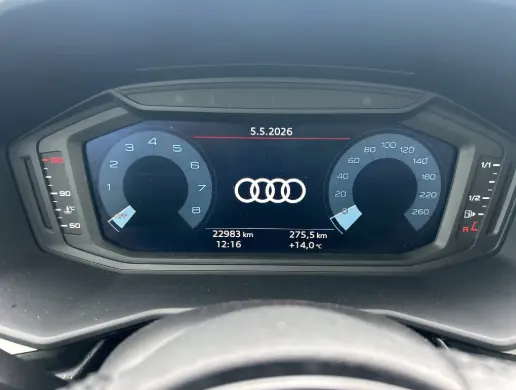 Vue rapprochée du cockpit numérique de l'Audi A1 Sportback gris, affichant compte-tours, vitesse et informations de trajet.