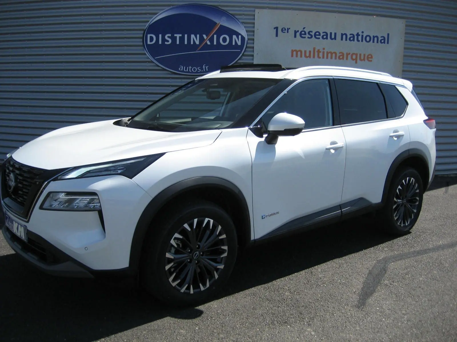 Nissan X-Trail blanc nacré en 3/4 avant droit, avec jantes bi-ton et détails noirs contrastants.