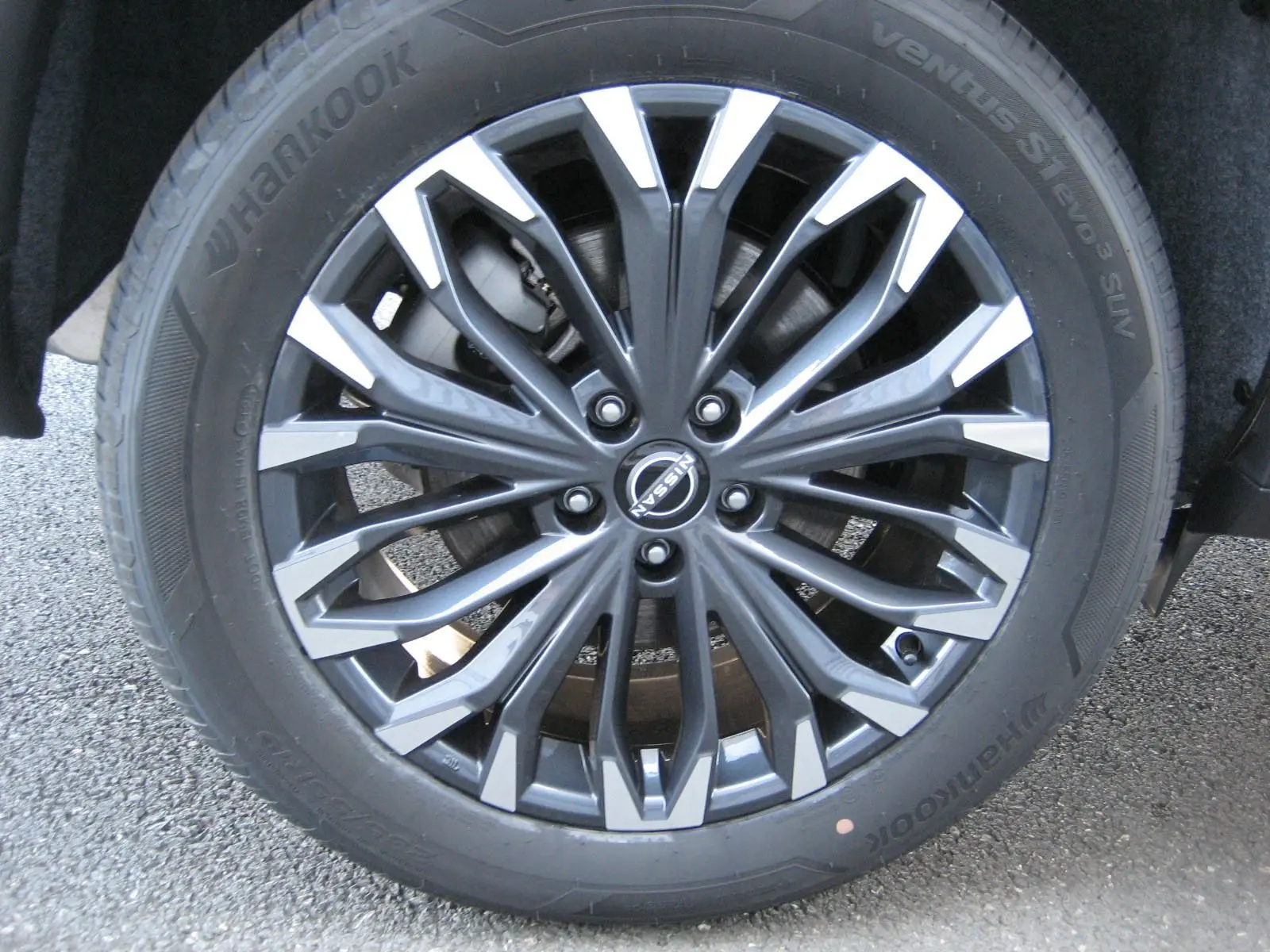 Gros plan sur la jante alliage bicolore gris et argent du Nissan X-Trail blanc nacré 2026.
