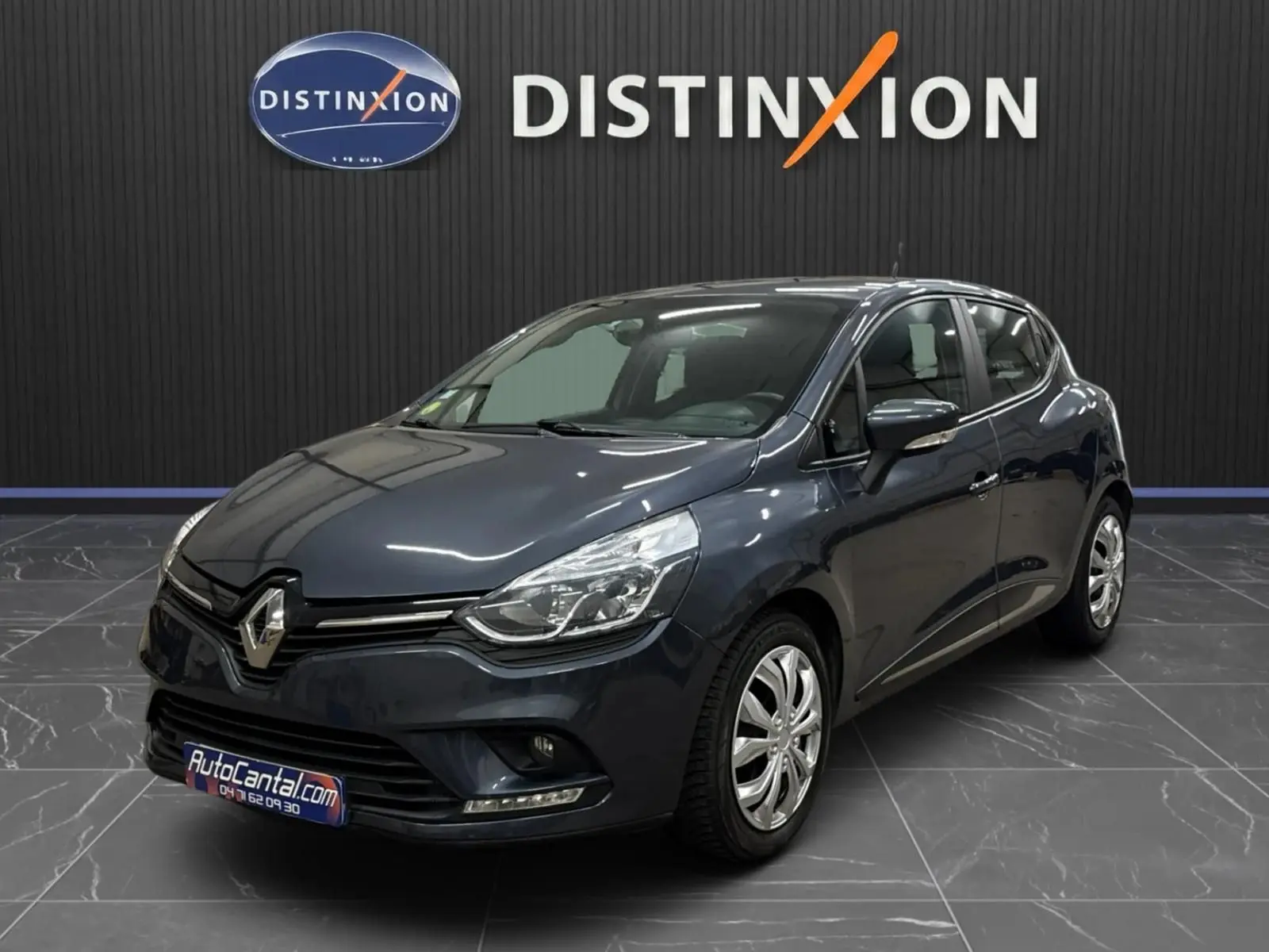 Renault Clio IV gris foncé métal vue 3/4 avant droite, avec phares LED et jantes alliage visibles en showroom.