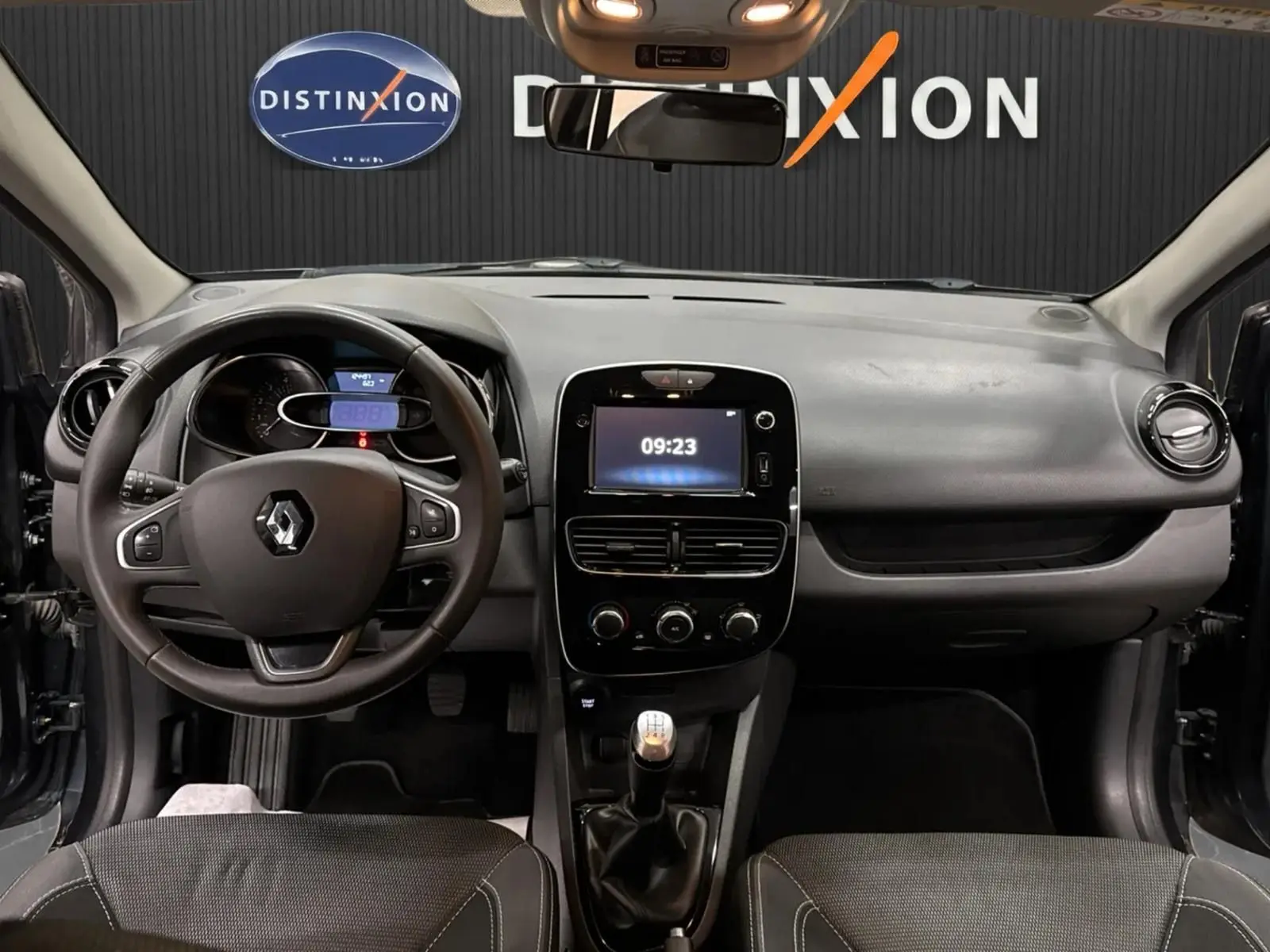 Vue intérieure avant de la Renault Clio IV 1.5 DCI 90 ch avec tableau de bord gris et volant multifonction.