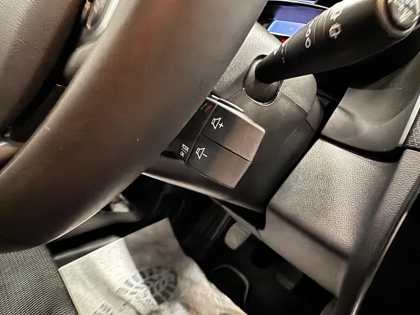 Vue rapprochée du volant et des commandes audio sur la colonne de direction d’une Renault Clio IV gris foncé.
