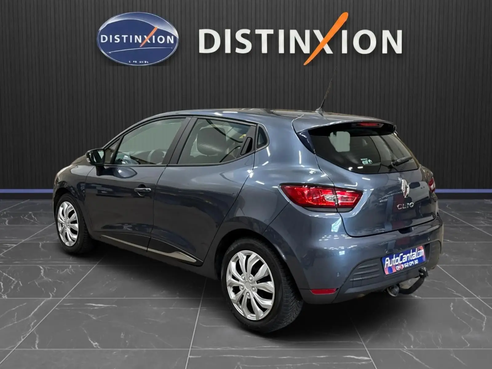 Renault Clio IV gris foncé métal vue 3/4 arrière droit, avec attelage et jantes alliage.