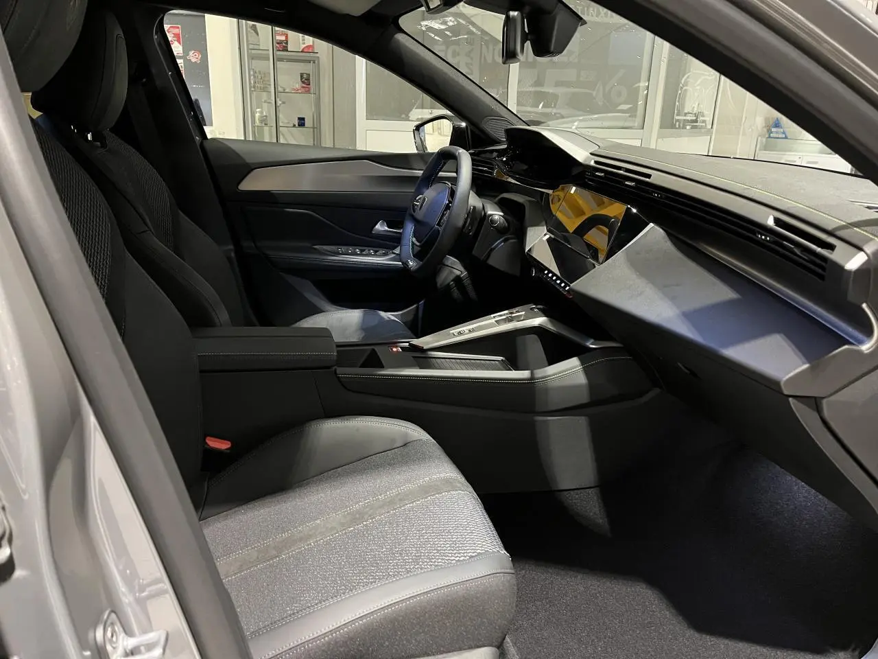 Intérieur avant droit de la Peugeot 308 gris selenium, avec tableau de bord moderne et sellerie tissu/TEP noire.