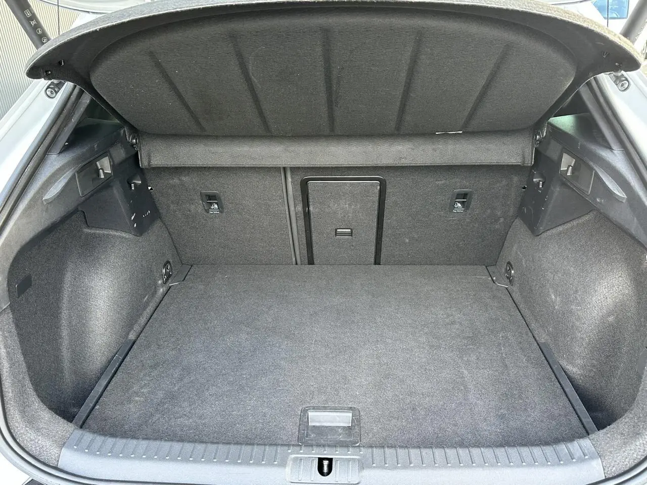 Coffre ouvert de la CUPRA Formentor blanc Neige, vue intérieure montrant le tapis et la trappe à skis.