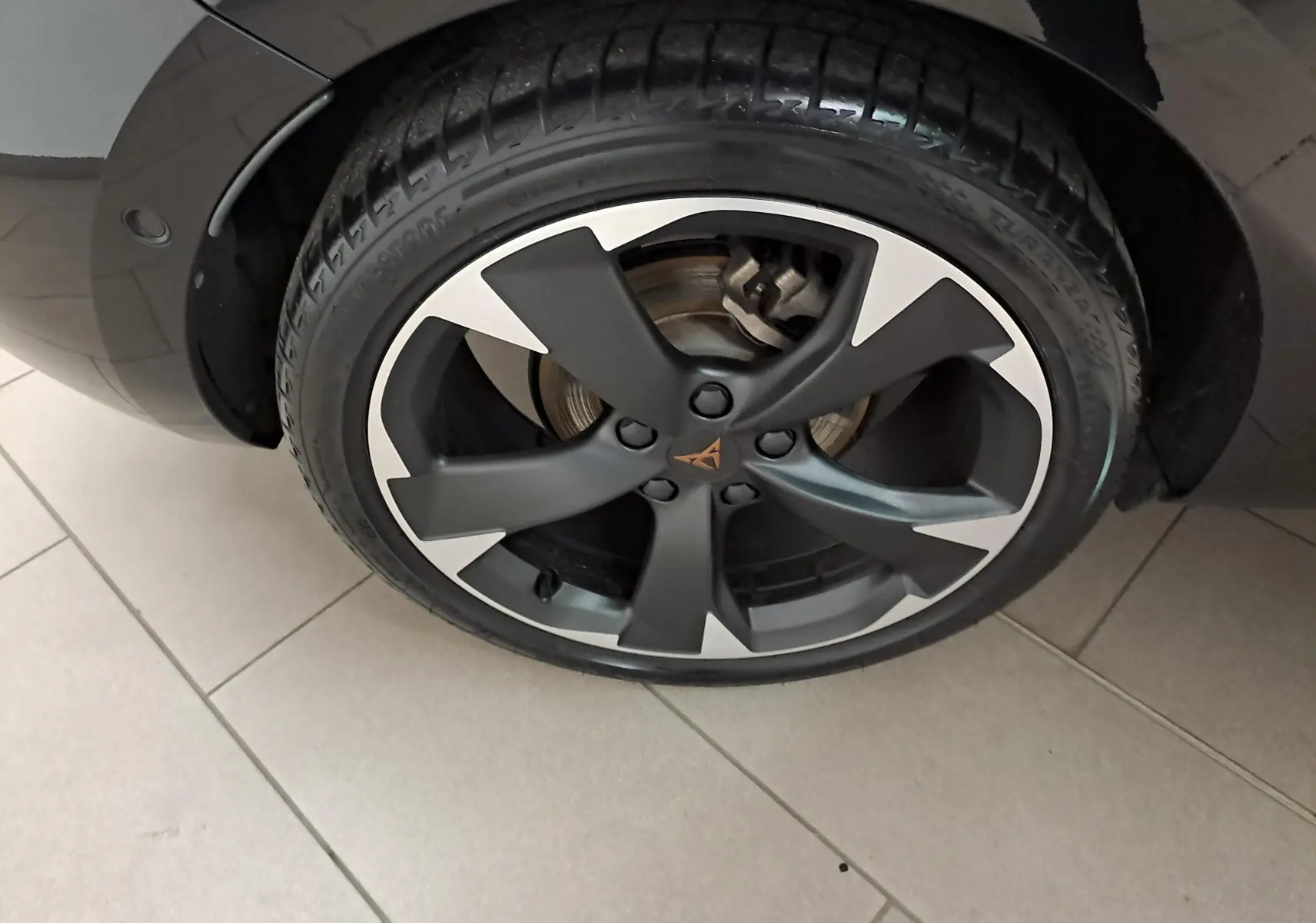 Gros plan sur la roue avant gauche de la CUPRA Leon 2023 en Noir Minuit avec jante alliage noire et argentée au design distinctif.