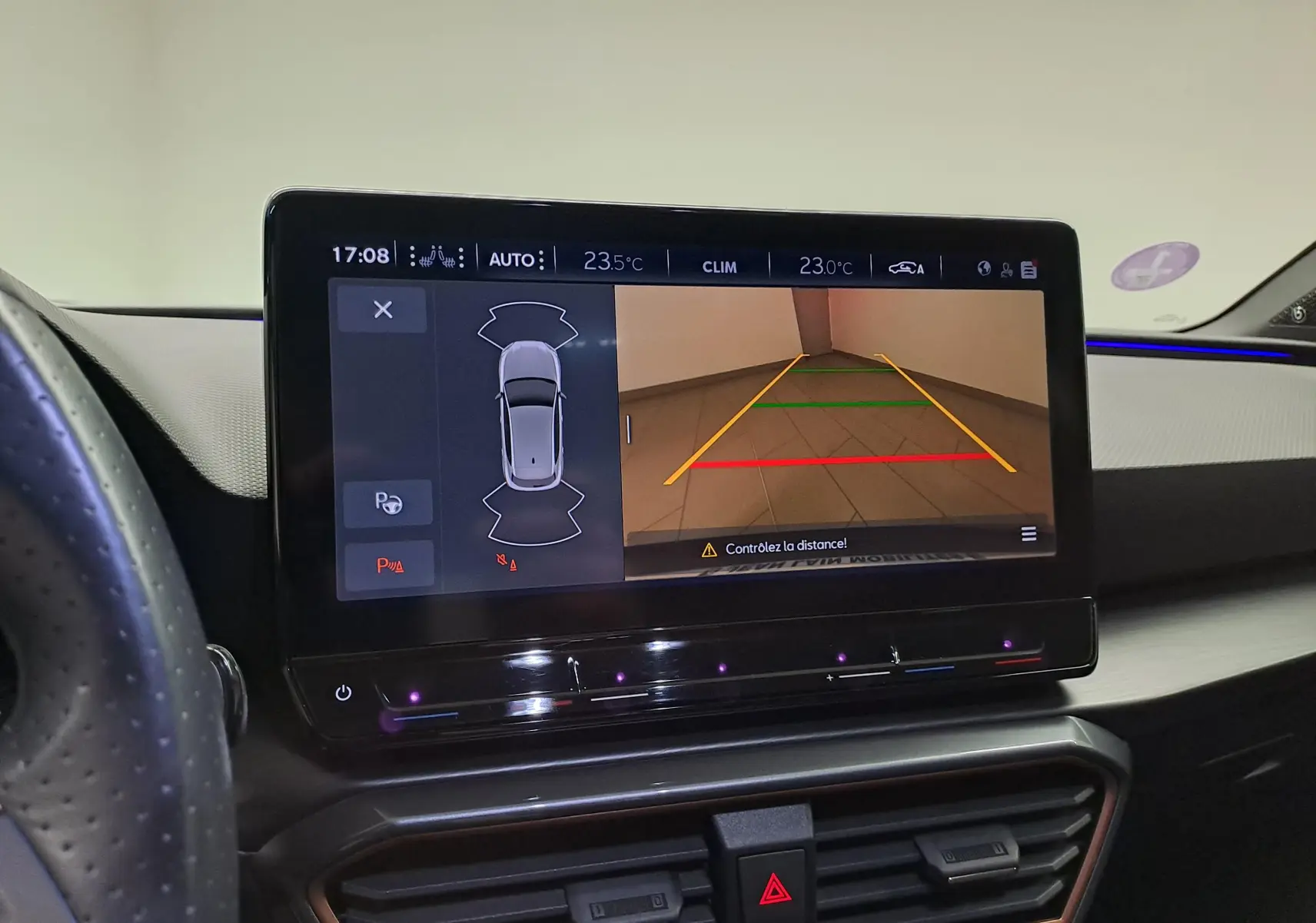 Écran tactile intérieur affichant la caméra de recul et l’aide au stationnement dans une CUPRA Leon Noir Minuit 2023.