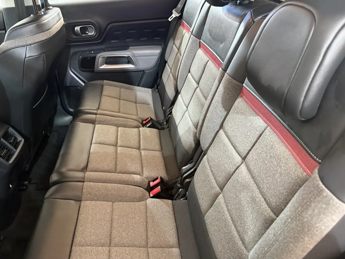 Vue latérale des sièges arrière gris et noirs avec surpiqûres rouges du Citroën C5 Aircross 2021.