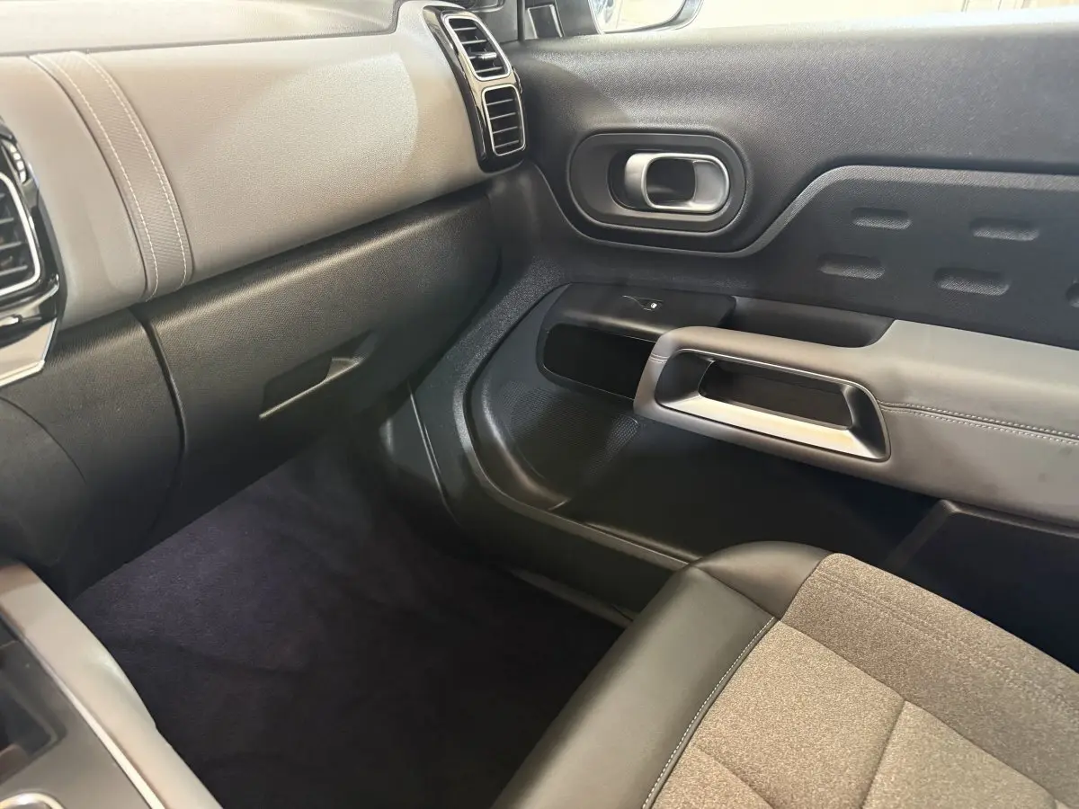 Intérieur côté passager du Citroën C5 Aircross 2021, montrant la porte et le tableau de bord en noir et beige.