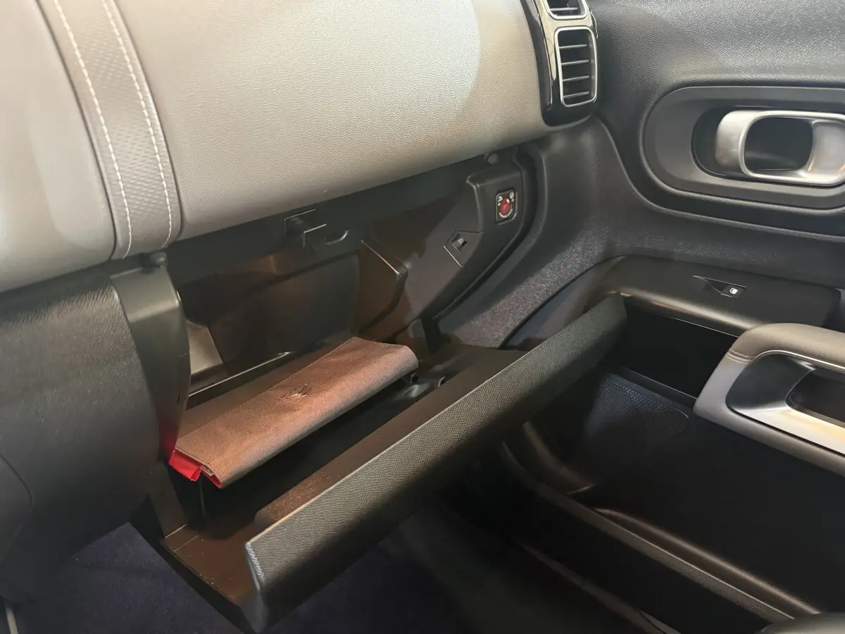 Vue intérieure côté passager du coffre à gants ouvert du Citroën C5 Aircross bleu avec détails du tableau de bord noir et gris.