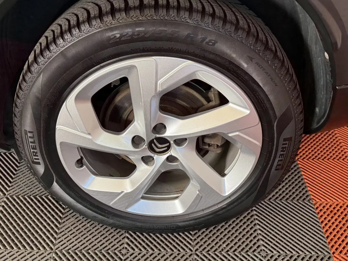 Gros plan sur la roue avant gauche avec jante argentée et pneu Pirelli du Citroën C5 Aircross bleu.