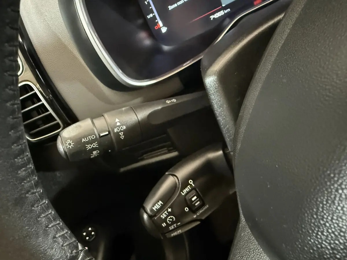 Gros plan sur le volant cuir et les commandes du régulateur de vitesse du Citroën C5 Aircross bleu, intérieur avant.