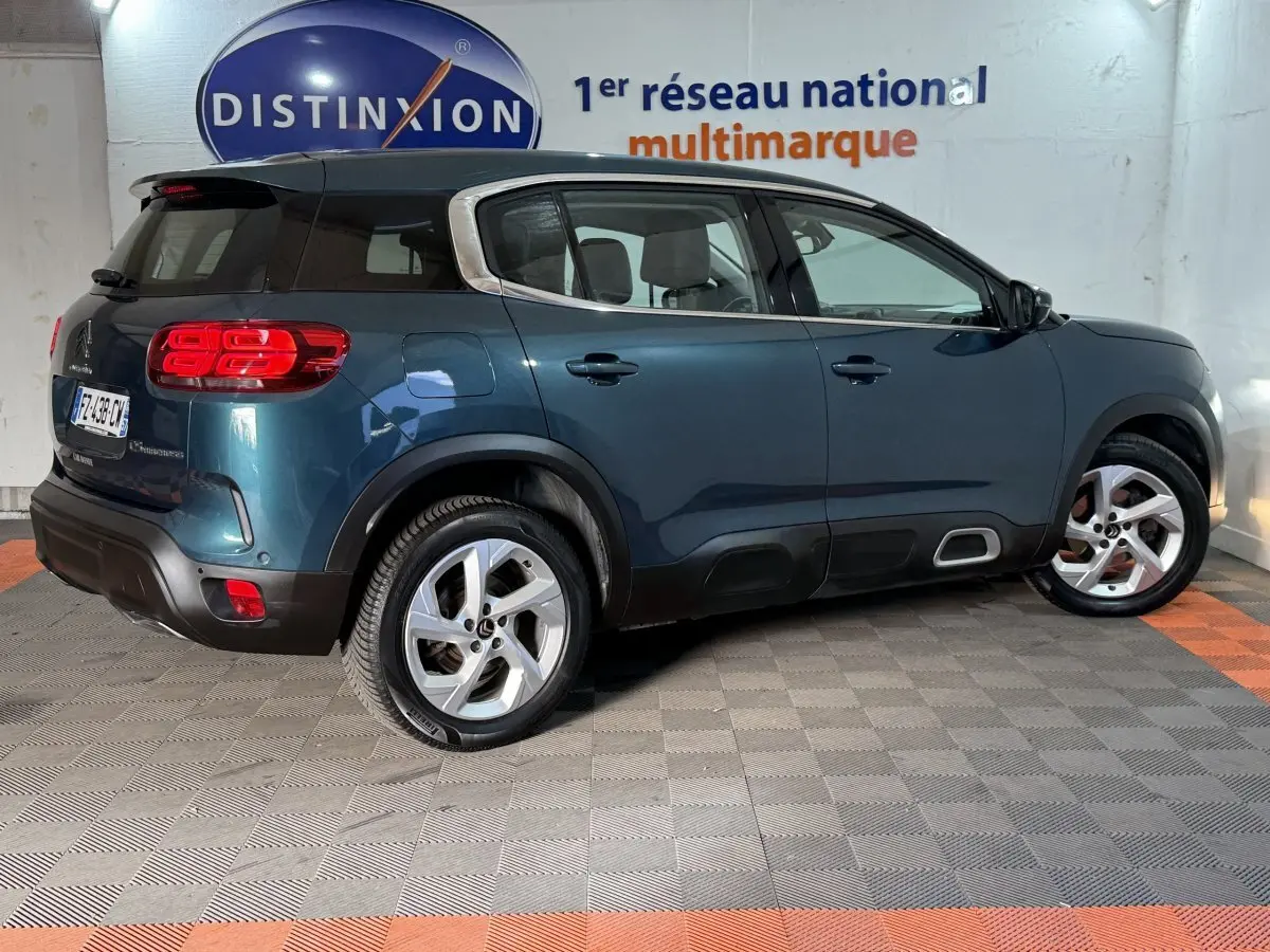 Vue latérale droite d'un Citroën C5 Aircross bleu 2021 avec toit noir et jantes alliage cinq branches.