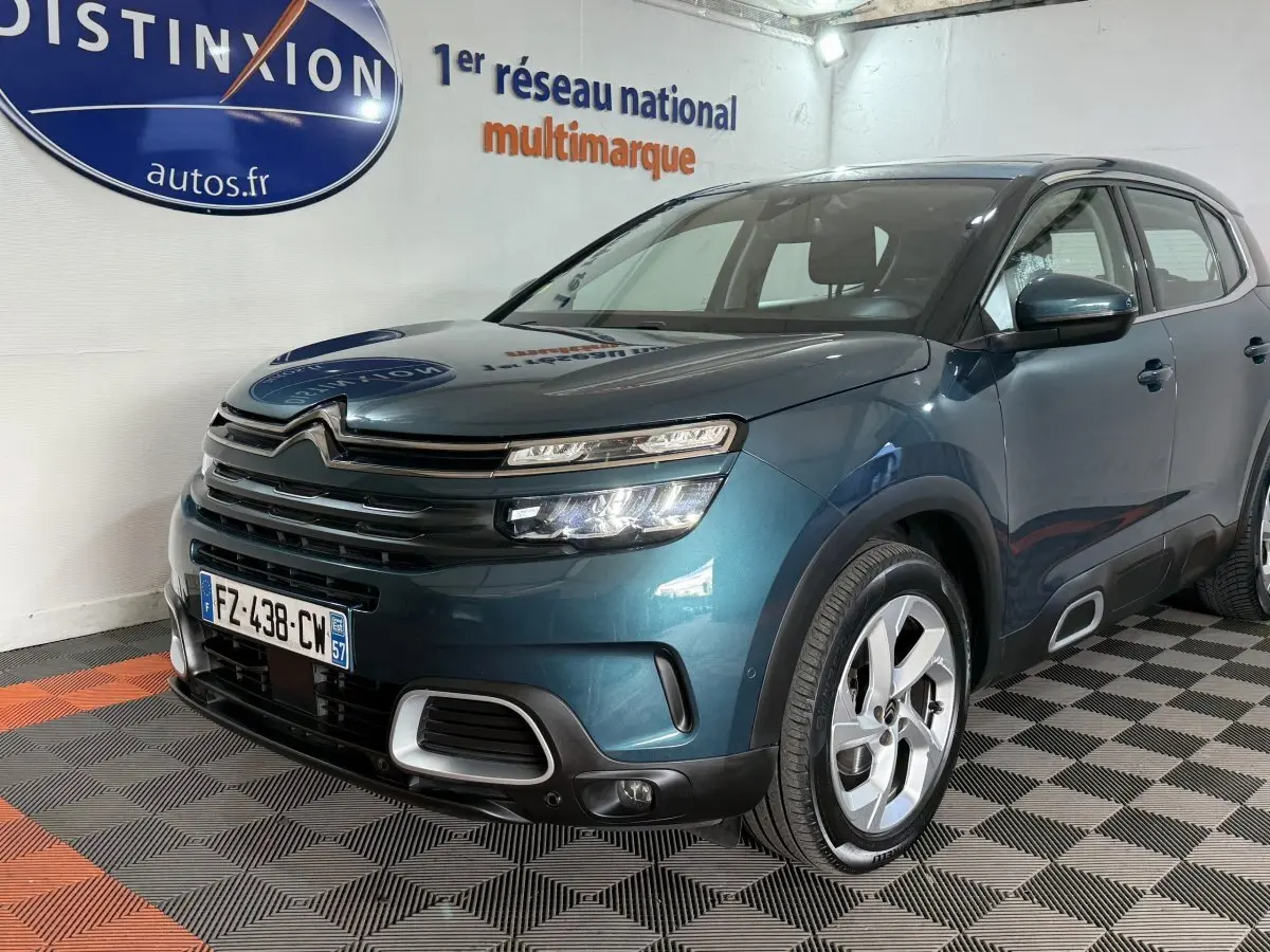 Vue 3/4 avant droite d'un Citroën C5 Aircross bleu avec calandre distinctive et jantes alliage modernes.
