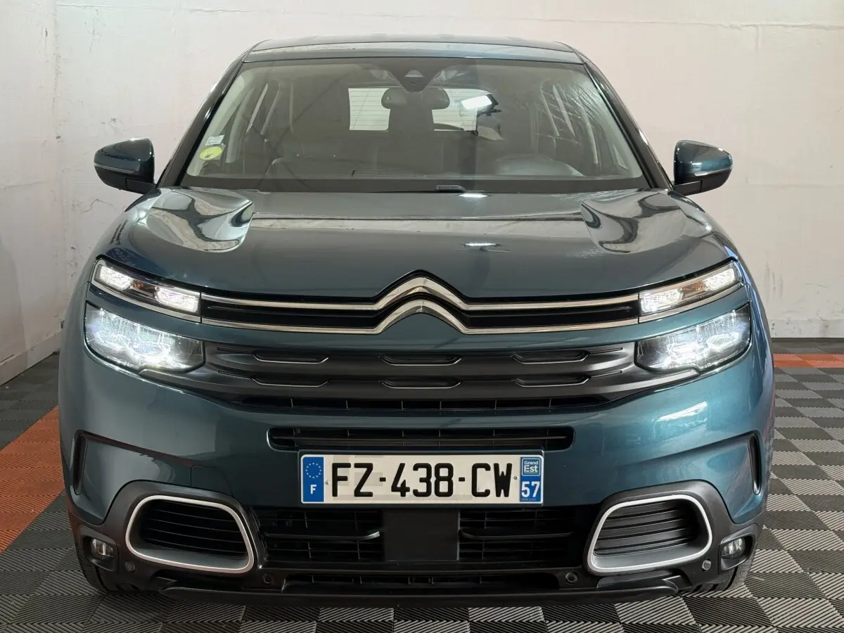 Vue avant d'un Citroën C5 Aircross bleu avec phares LED allumés et calandre chromée distinctive.