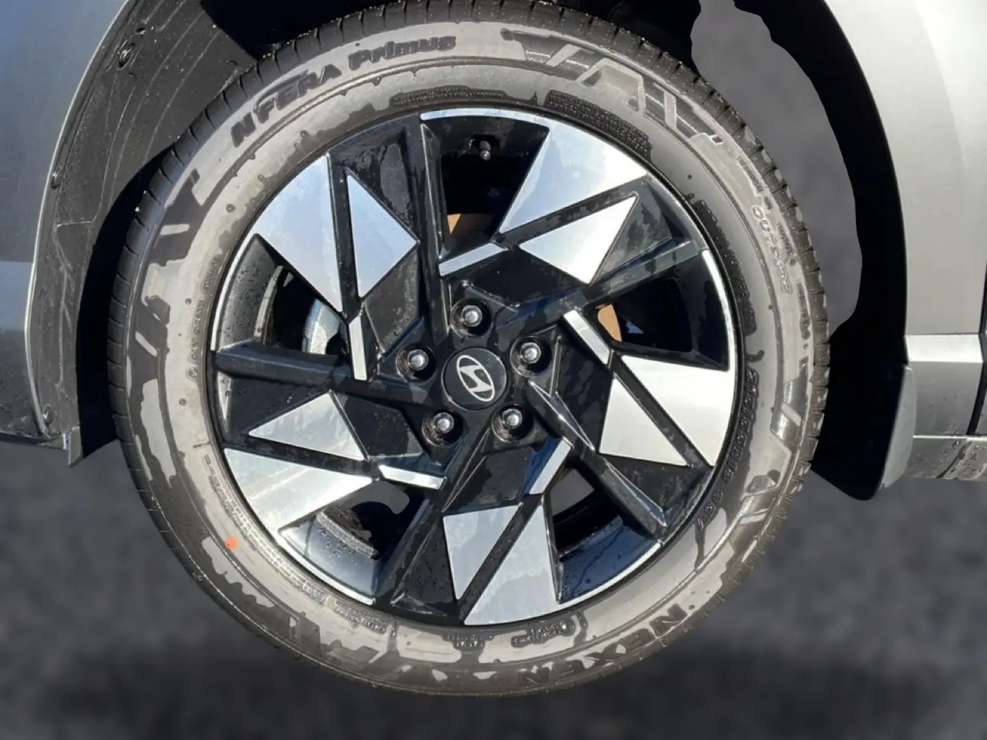 Gros plan sur la jante alliage 18 pouces noire et argentée du Hyundai Kona 2025 noir, avec pneu Nexen visible.