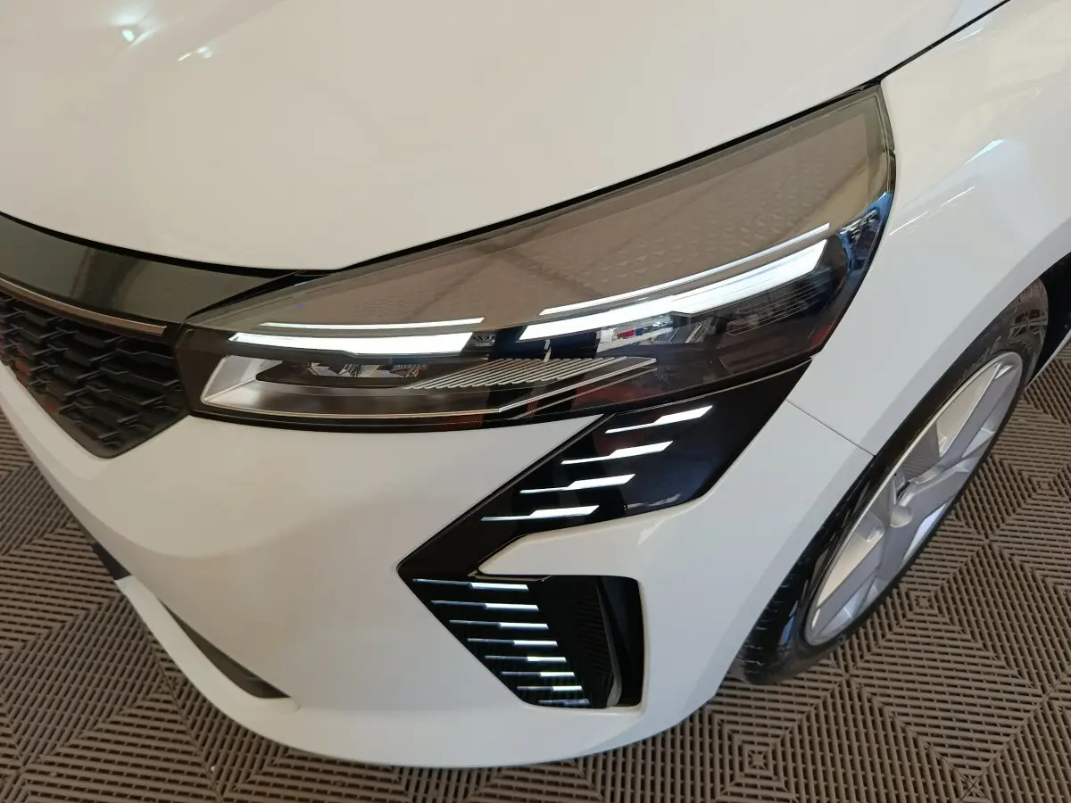 Gros plan sur l'avant droit blanc de la Renault Clio 2024 avec phares LED et détails lumineux distinctifs.
