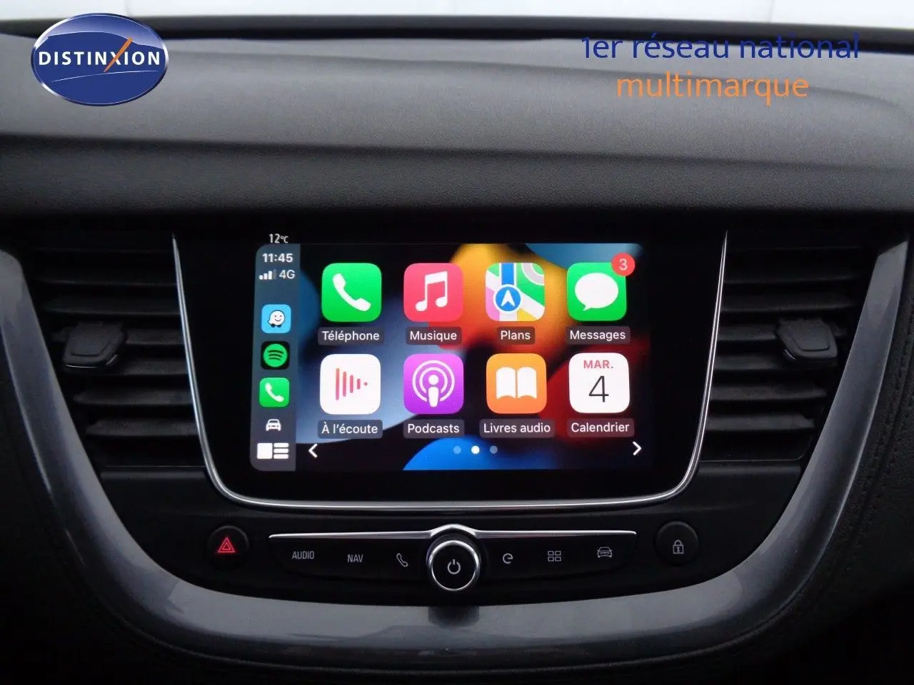 Écran tactile central allumé dans l’habitacle d’un Opel Grandland X blanc métal, vue frontale rapprochée.