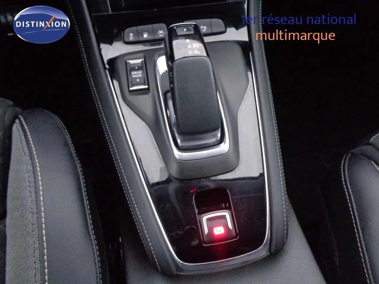 Vue rapprochée de la console centrale noire avec levier de vitesse et bouton frein à main électrique de l’Opel Grandland X blanc métal.