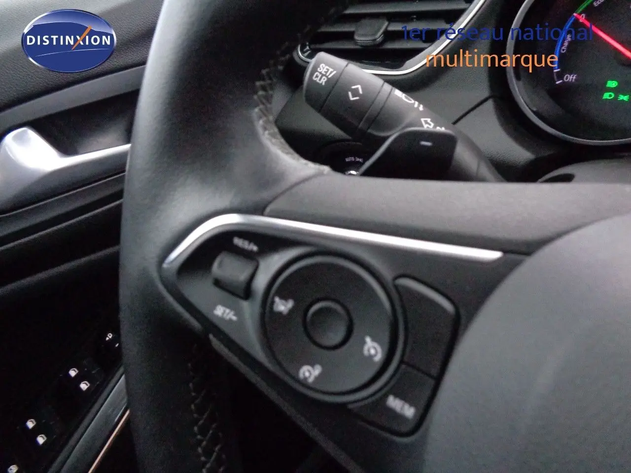 Gros plan sur le volant noir de l’Opel Grandland X 1.6 Hybrid Turbo 2021, avec commandes intégrées visibles.