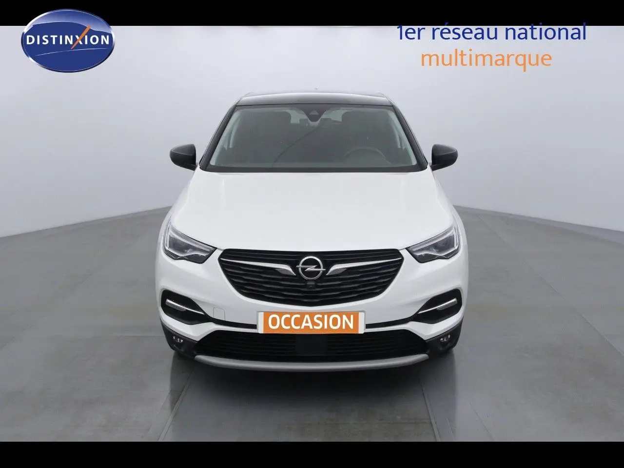 Vue avant d'un Opel Grandland X blanc métal hybride rechargeable avec calandre noire et phares LED allumés.