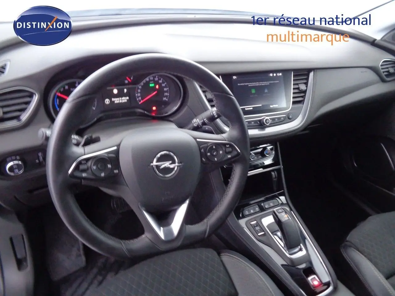 Intérieur noir de l’Opel Grandland X 1.6 Hybrid Turbo 2021, vue centrée sur le volant et la console centrale.