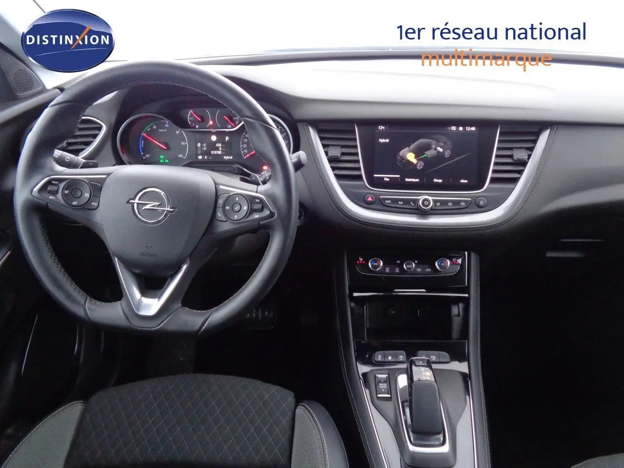Vue intérieure du poste de conduite de l’Opel Grandland X hybride, avec volant multifonction et écran central tactile.
