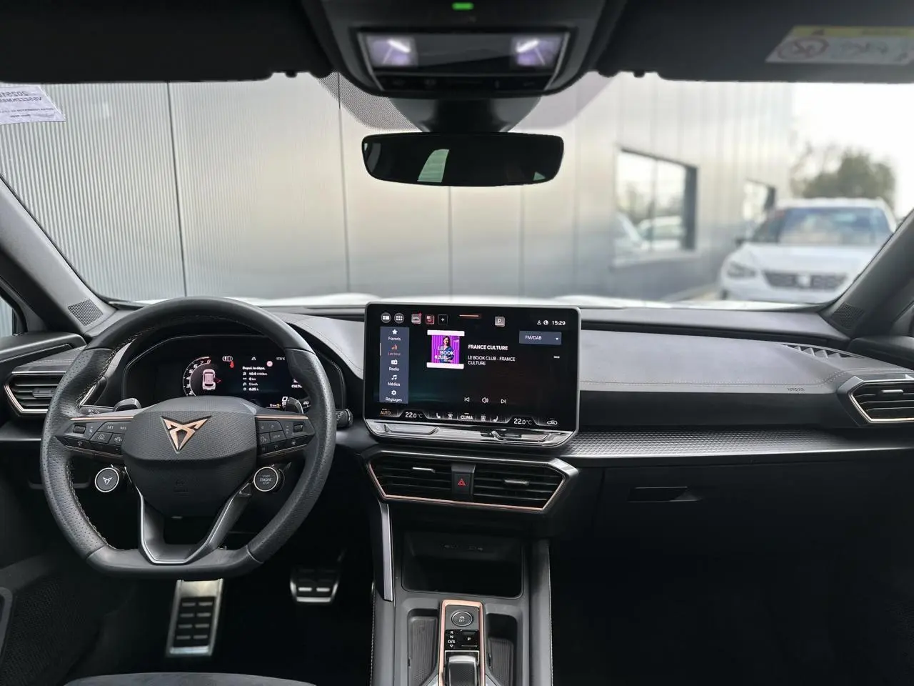 Vue intérieure avant du CUPRA Formentor blanc Neige 2025, tableau de bord moderne avec écran tactile et volant Supersports cuir.