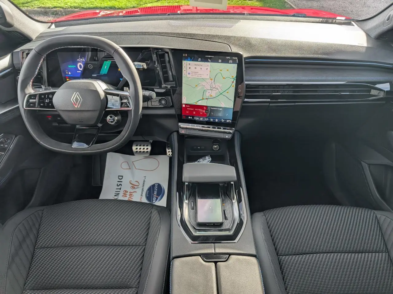 Vue intérieure frontale du Renault Austral Esprit Alpine 2025, avec tableau de bord noir et écran tactile central affichant la navigation.