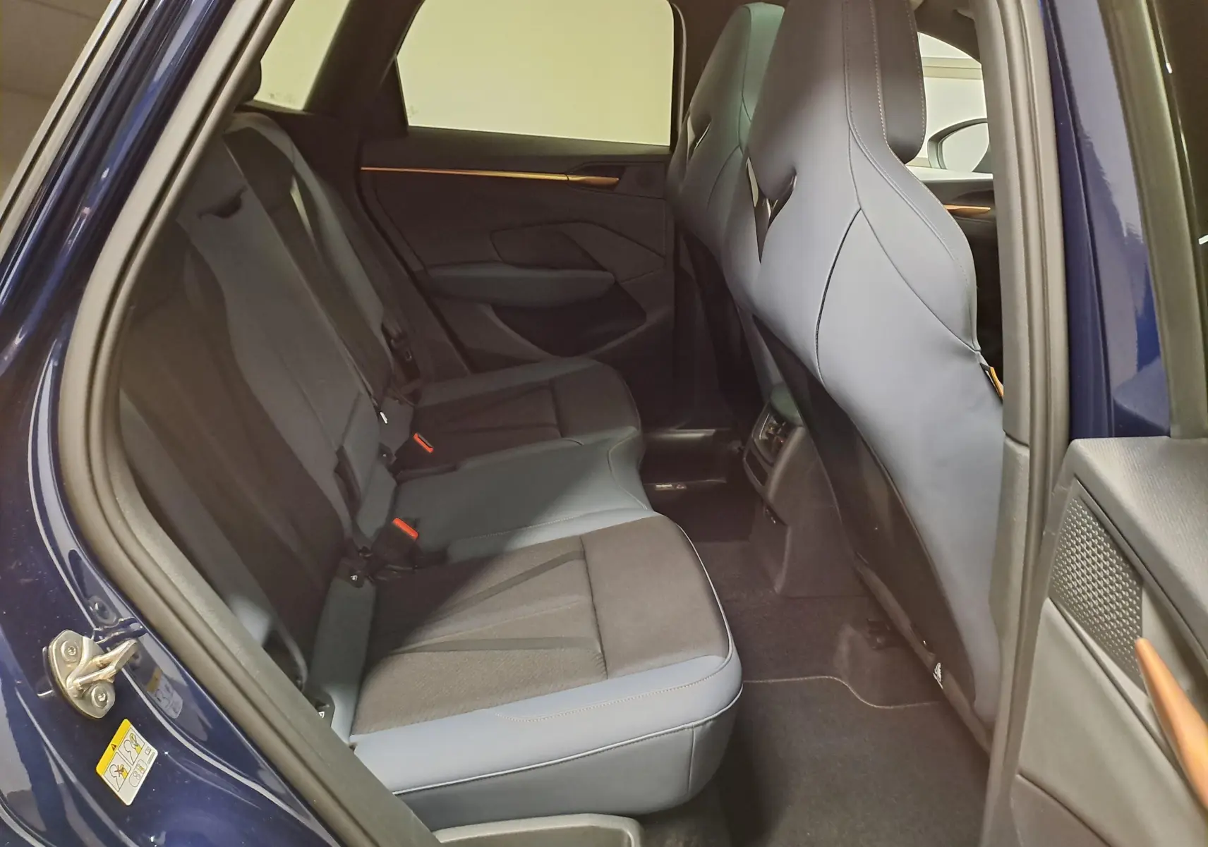 Vue intérieure côté gauche des sièges arrière en tissu et cuir gris d'un CUPRA TERRAMAR Bleu Cosmos 2025 avec portes ouvertes.