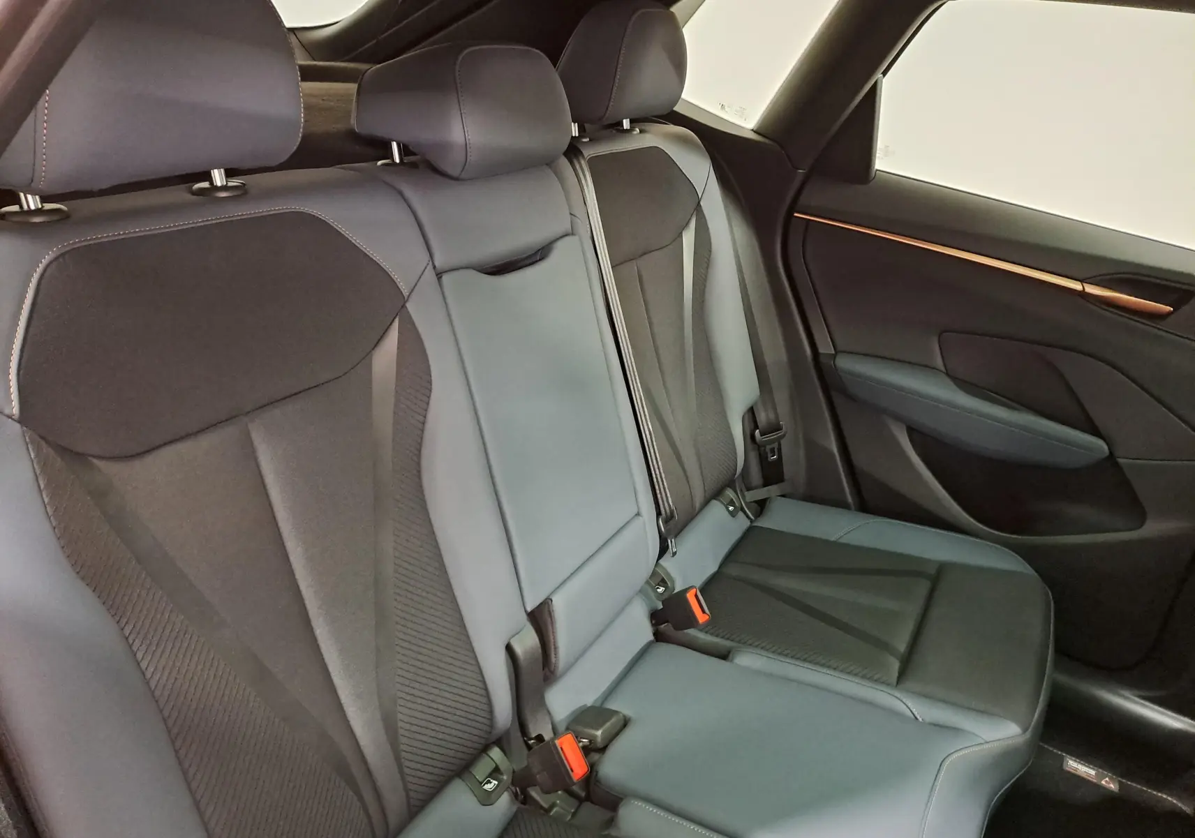 Vue intérieure côté droit des sièges arrière en cuir noir et tissu du CUPRA TERRAMAR 2025 avec finitions soignées.