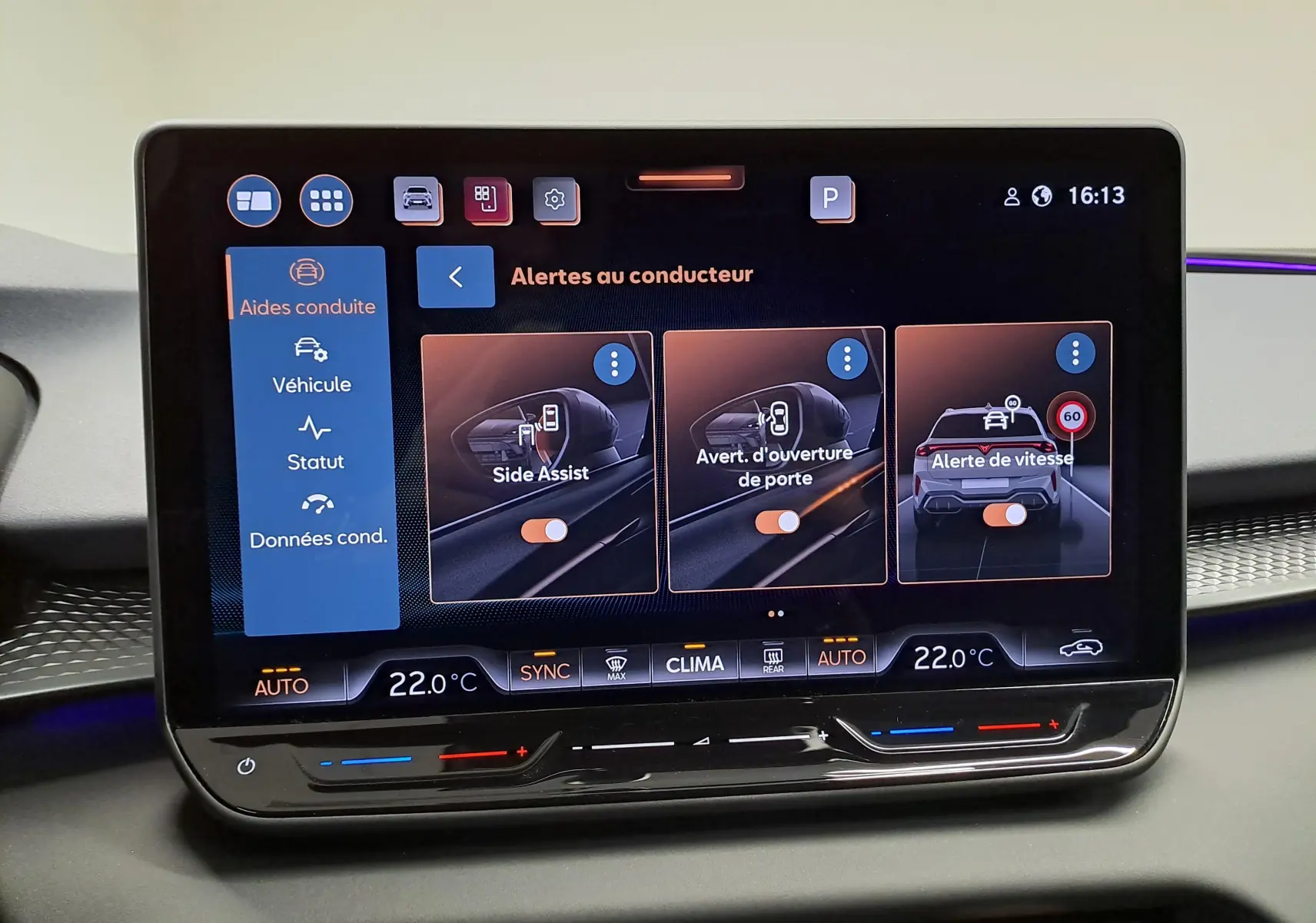 Écran tactile central du CUPRA TERRAMAR 2025 affichant les alertes au conducteur avec interface moderne et commandes climatiques.