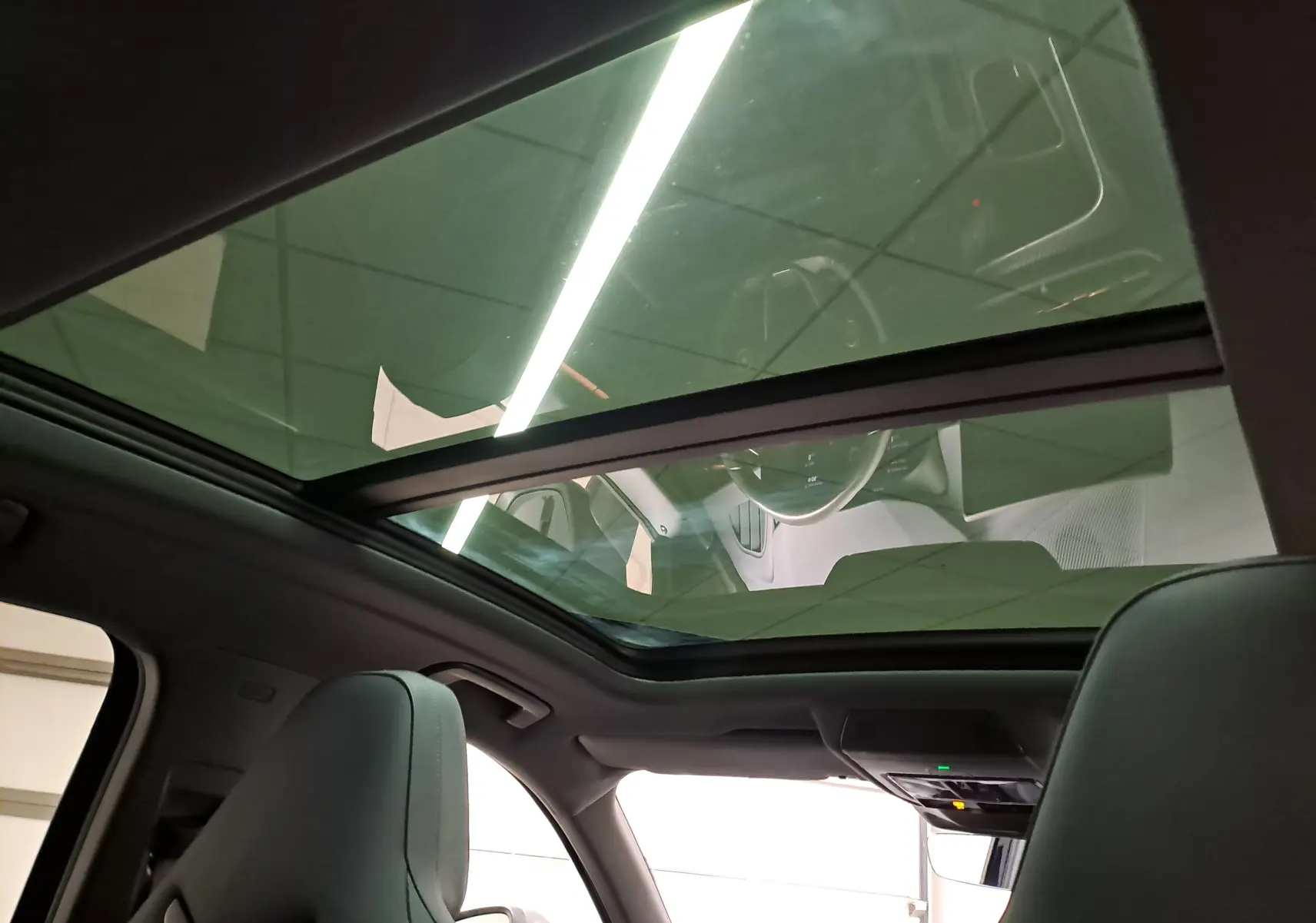 Vue intérieure du toit ouvrant panoramique du CUPRA Terramar 2025, avec sièges avant et tableau de bord visibles.